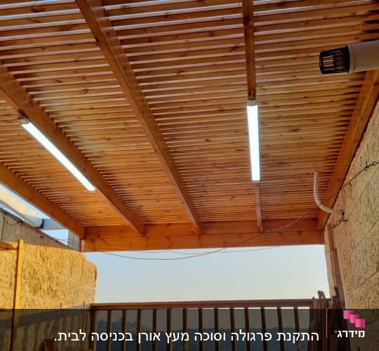 תקרה מעץ עם תאורה ומעקה עץ